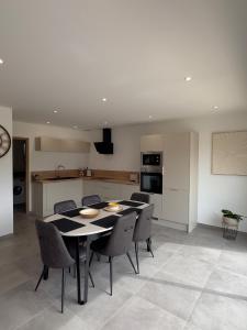 a kitchen and a dining room with a table and chairs at La maison des étangs in Rebecques