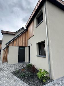 a white house with a black door at La maison des étangs in Rebecques