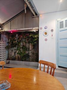 a table in a room with a plant on the wall at Vila Urban Hostel ॐ Jardins in São Paulo