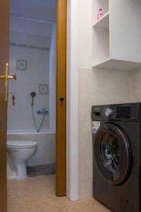 a bathroom with a washing machine and a toilet at Square House in Levkopiyí