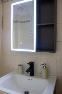 a bathroom sink with a mirror and aaucet at Square House in Levkopiyí