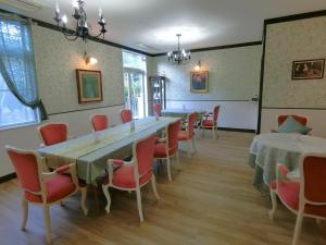 a room with a long table and chairs at Utena Izukogen in Ito