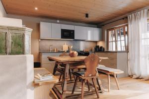 a kitchen with a table and chairs and a refrigerator at Alpenchalet Reit im Winkl in Reit im Winkl