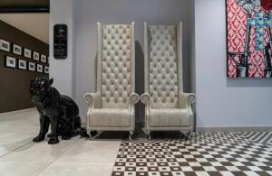 a black dog sitting next to two chairs at NYX Hotel Milan by Leonardo Hotels in Milan