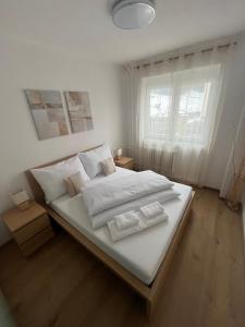 a bedroom with a large bed with white sheets and pillows at Apartmán Ella - Riegrova 41 in Děčín