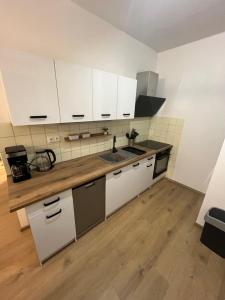a kitchen with white cabinets and a sink at Apartmán Ella - Riegrova 41 in Děčín