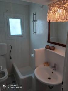 a white bathroom with a sink and a toilet at Debbie's Apartments in Adamantas