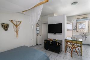 a bedroom with a bed and a tv on a wall at Debbie's Apartments in Adamantas