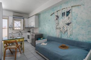 a room with a bed and a table and a kitchen at Debbie's Apartments in Adamantas