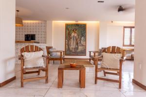 a living room with chairs and a painting on the wall at Hotel Suites Villasol in Puerto Escondido