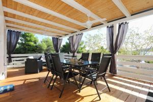 a dining room with a table and chairs on a deck at Ahoi Hause 10 Strandhaus mit Meerblick & privatem Zugang in Drage +80 photos