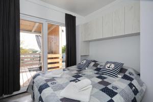 a bedroom with a checkered bed with two pillows at Ahoi Hause 10 Strandhaus mit Meerblick & privatem Zugang in Drage