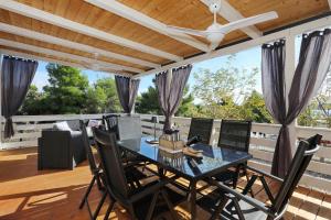 a dining room with a table and chairs on a deck at Ahoi Hause 10 Strandhaus mit Meerblick & privatem Zugang in Drage