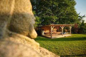 a wooden pavilion in a park with a tree at Arboretum Vlasenice in Vlasenice