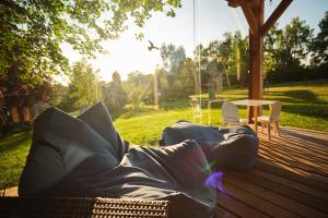 a blanket laying on a wooden deck with a table at Arboretum Vlasenice in Vlasenice