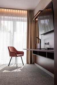 a room with a desk and a chair and a sink at Hotel Marton in Koszalin