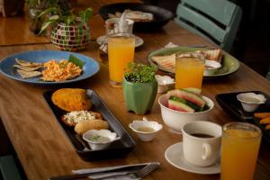 a wooden table topped with plates of food and drinks at Hotel Barahona Cartagena in Cartagena de Indias