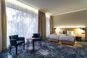 a hotel room with a bed and two chairs and a table at Hotel Marton in Koszalin +43 photos
