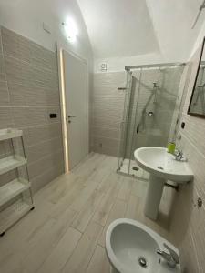 a white bathroom with a sink and a shower at Home Ringo in Belvedere Marittimo +10 photos