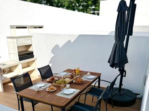 a table with food and an umbrella on a patio at Alma de Areia - Alma Nossa in Montijo