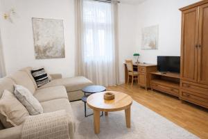 a living room with a couch and a tv at Vila Bellevue in Luhačovice
