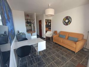 a living room with a couch and a table at La Bella Vista - appartement classé 2 étoiles in Mèze