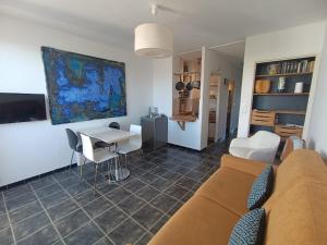 a living room with a couch and a table at La Bella Vista - appartement classé 2 étoiles in Mèze