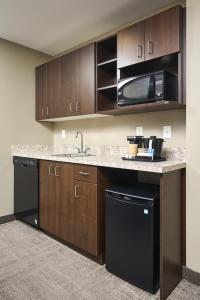 a kitchen with a sink and a microwave at Canad Inns Destination Centre Transcona in Winnipeg