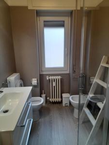 a bathroom with a sink and a toilet and a window at Casa Vacanza dei Nonni in Varzo +6 photos