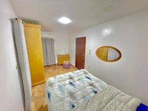 a bedroom with a bed and a mirror on the wall at Yellow House on the Nile in Luxor