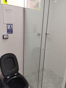 a bathroom with a black toilet in a stall at quarto 3 pra 4 pessoas in Ouro Preto