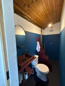 a bathroom with a toilet and a sink with a mirror at Hostel Caraivando in Caraíva +39 photos