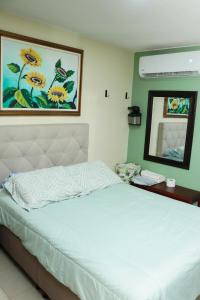 a bedroom with a white bed with a mirror at Spazio83 in Puerto Colombia