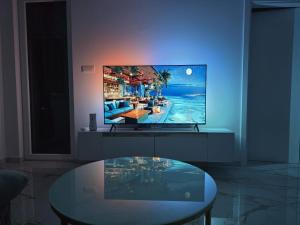 a living room with a tv and a glass table at Splendida in Bosanska Gradiška
