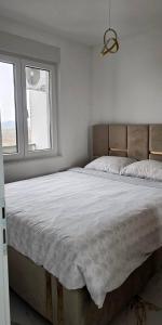 a white bedroom with a large bed and a window at Splendida in Bosanska Gradiška