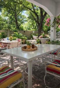 a white table and chairs in a patio with trees at La Casita Inn Bustamante in Bustamante