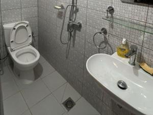 a bathroom with a toilet and a sink at Studio Meublé in Rufisque +4 photos