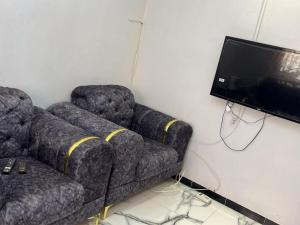 a living room with a couch and a flat screen tv at Studio Meublé in Rufisque