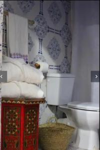 a bathroom with a toilet and a bunch of towels at Riad Dar Dahlia Tetouan in Tétouan +16 photos