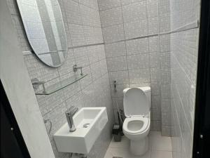a bathroom with a toilet and a sink and a mirror at Studio Meublé in Rufisque