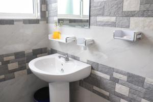 a bathroom with a white sink and a mirror at The kandy downtown in Katugastota