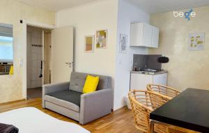 a living room with a couch and a yellow pillow at BEGE APARTMENTS CitySleep in Aachen