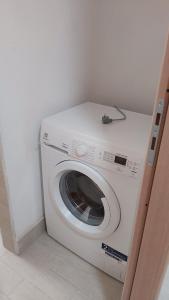 a white washing machine in a corner of a room at Alisia Apartment in Rossano Stazione