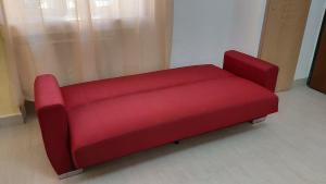 a red couch sitting in a living room at Alisia Apartment in Rossano Stazione
