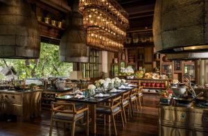 una cocina con una mesa larga y sillas en Four Seasons Resort Chiang Mai, en Mae Rim