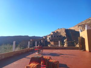 a person standing on top of a building with a mountain at Pergolas Tamakouchte in Ouarzazate