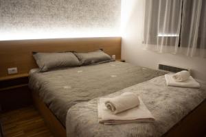a bedroom with a bed with towels on it at Apartman Mireli in Zlatibor
