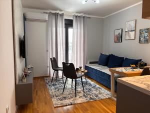 a living room with a blue couch and a table and chairs at Apartman Mireli in Zlatibor