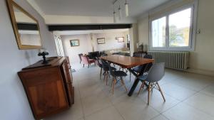 a dining room with a wooden table and chairs at La Villa Estran in Saint-Gilles-Croix-de-Vie