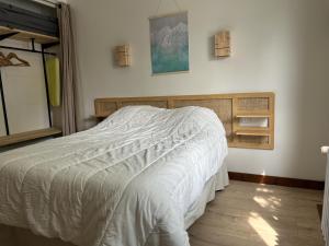 a bedroom with a bed with a white comforter at La Villa Estran in Saint-Gilles-Croix-de-Vie
